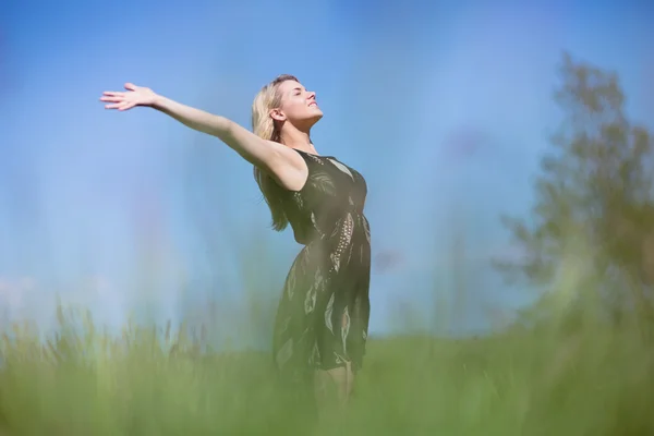 Bonita rubia en vestido de sol de pie con los brazos fuera — Foto de Stock