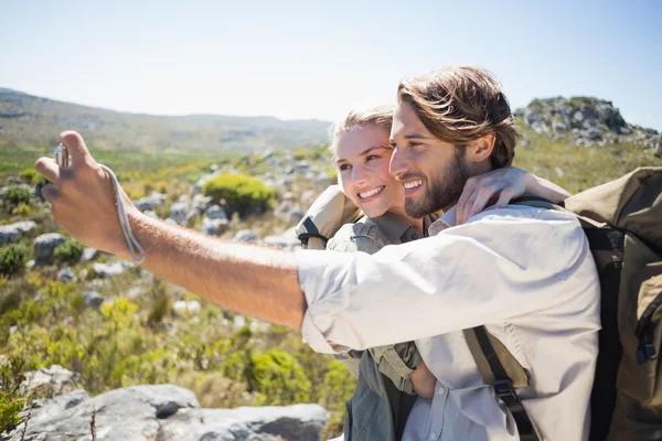 Casal em terreno de montanha tomando selfie — Fotografia de Stock