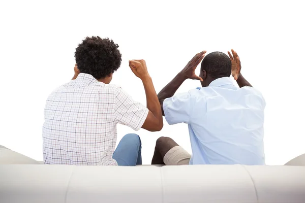 Rival sports fans sitting on the couch — Stock Photo, Image