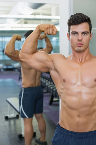 Hemdloser muskulöser Mann lässt in Turnhalle die Muskeln spielen — Stockfoto