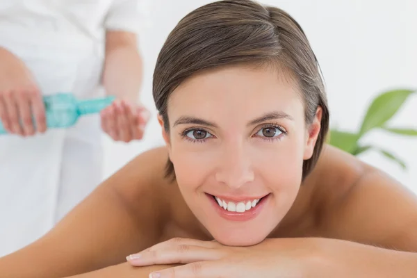 Attractive woman getting massage oil on her back — Stock Photo, Image