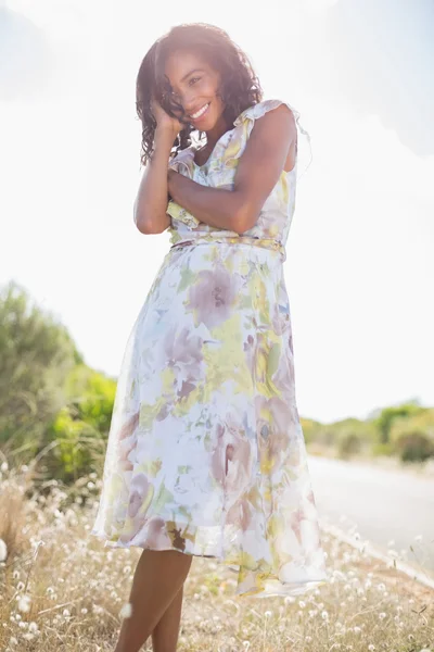 Hermosa mujer en vestido floral sonriendo a la cámara —  Fotos de Stock