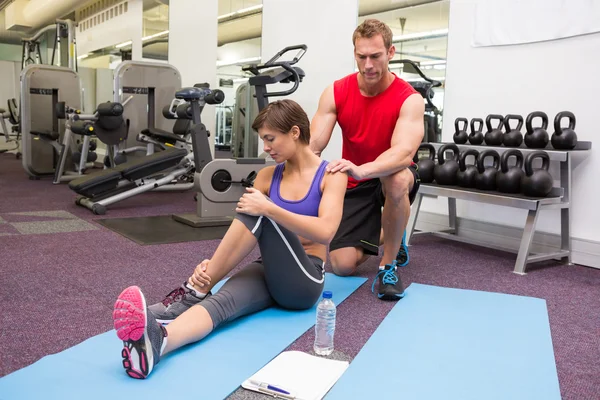 Personal trainer rubbing clients shoulders on mat — Stock Photo, Image