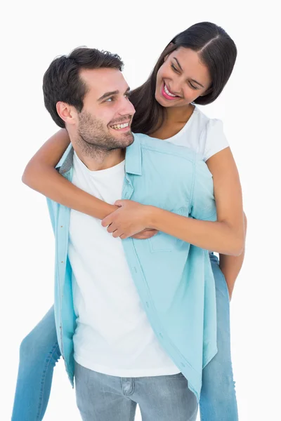 Feliz casual homem dando bonito namorada porquinho de volta — Fotografia de Stock