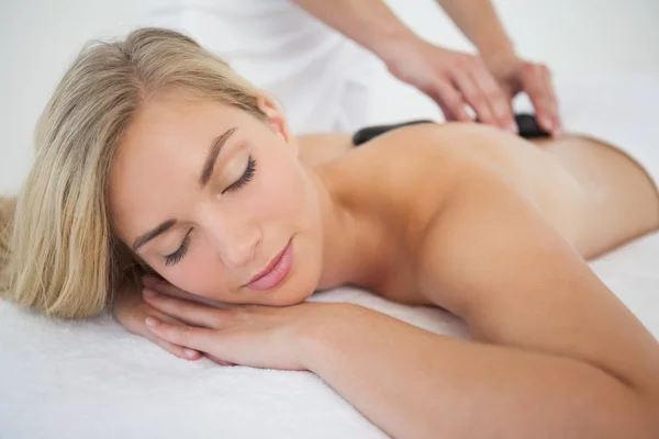 Vacker blondin njuter av en hot stone massage — Stockfoto