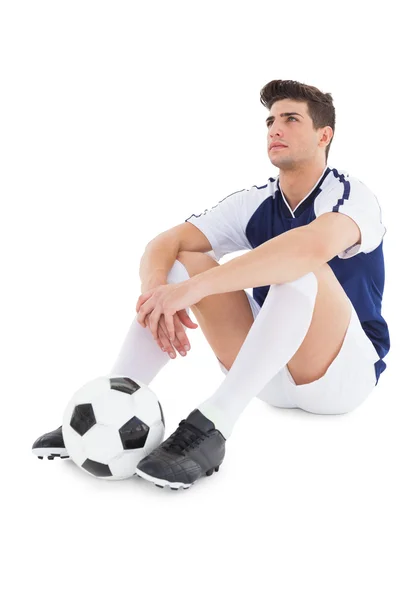 Jogador de futebol sentado no chão com bola — Fotografia de Stock