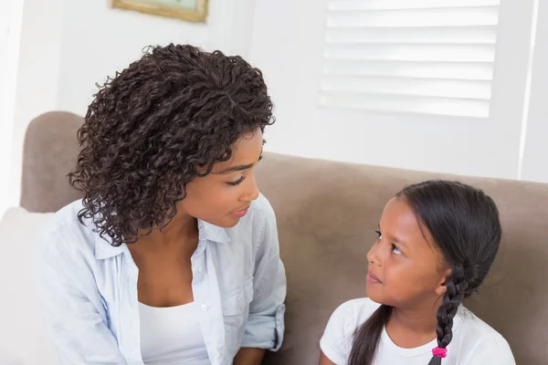 Jolie mère assise sur le canapé avec sa fille — Photo