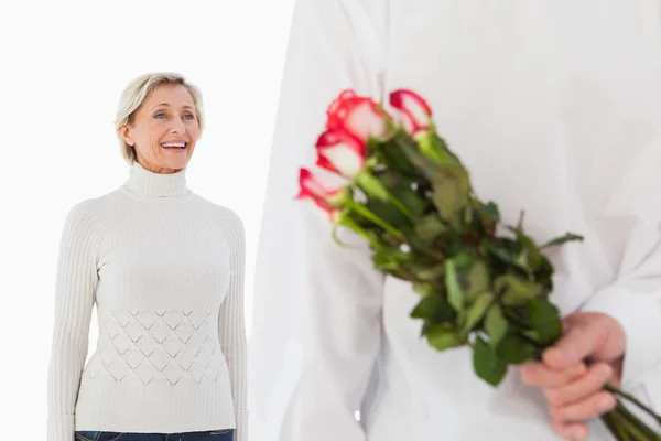 Чоловік ховає букет троянд від літньої жінки — стокове фото
