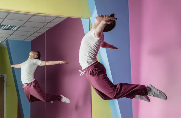 Cool break dancer mid air in front of mirror — Stock Photo, Image