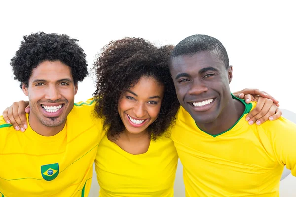 Happy brazilian football fans in yellow sitting on couch — Stock Photo, Image