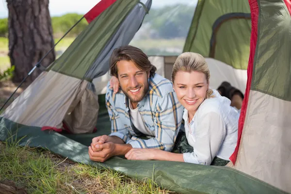 Pareja acostada en su tienda sonriendo — Foto de Stock