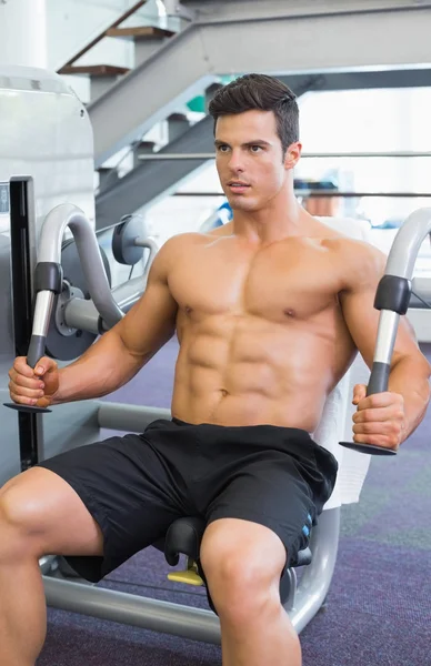 Hombre muscular trabajando en la máquina abdominal en el gimnasio — Foto de Stock