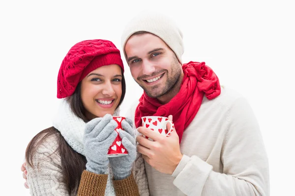 Atraente jovem casal em roupas quentes segurando canecas — Fotografia de Stock