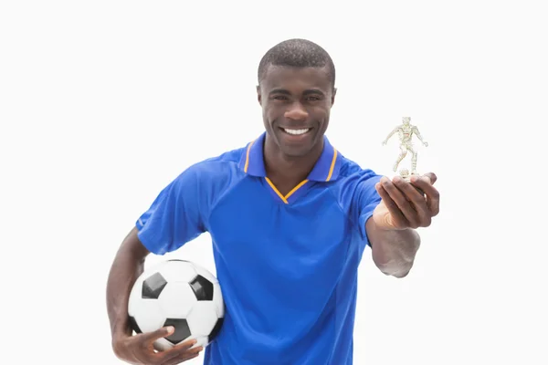 Футболист в синем с мячом и фигуркой — стоковое фото