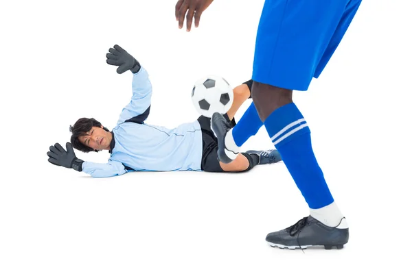 Striker golpeando el fútbol en portero — Foto de Stock