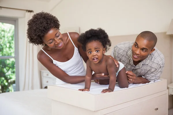 Parents with their baby girl on changing table — Stock Photo, Image