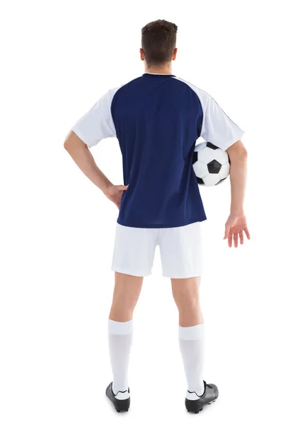 Jogador de futebol em camisa azul segurando bola — Fotografia de Stock