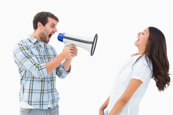 Злой мужчина кричит на девушку через мегафон — стоковое фото
