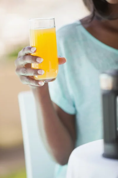 Smiling woman having orange juice outside — Stock Photo, Image