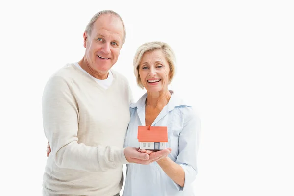 Šťastný starší pár s modelu domu — Stock fotografie