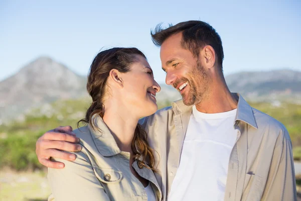 Caminhadas casal sorrindo um para o outro no campo — Fotografia de Stock