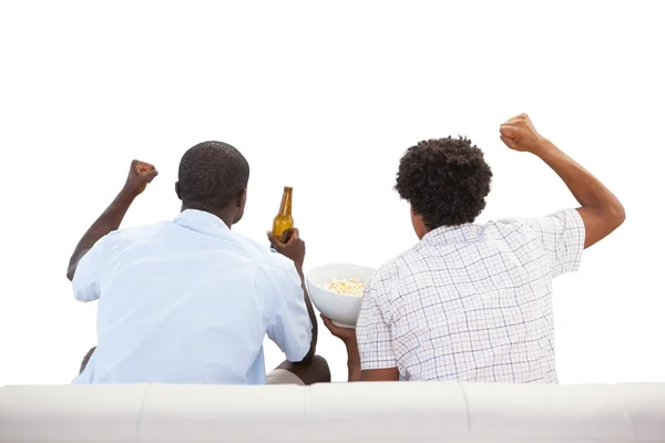 Cheering sports fans sitting on the couch with beers — Stock Photo, Image