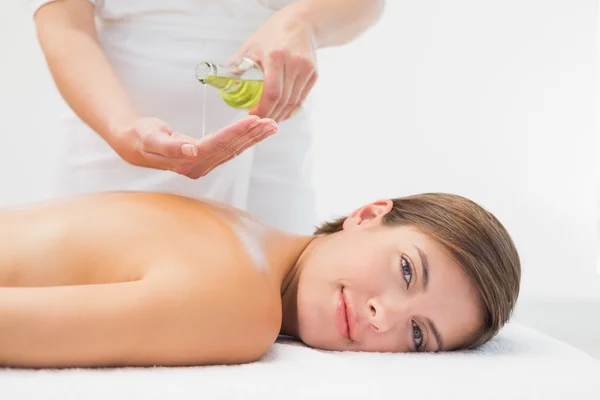 Atractiva mujer recibiendo aceite de masaje en su espalda — Foto de Stock