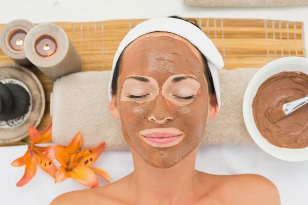 Smiling brunette getting a mud treatment facial — Stock Photo, Image