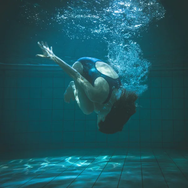 Athletische Schwimmerin beim Salto unter Wasser — Stockfoto