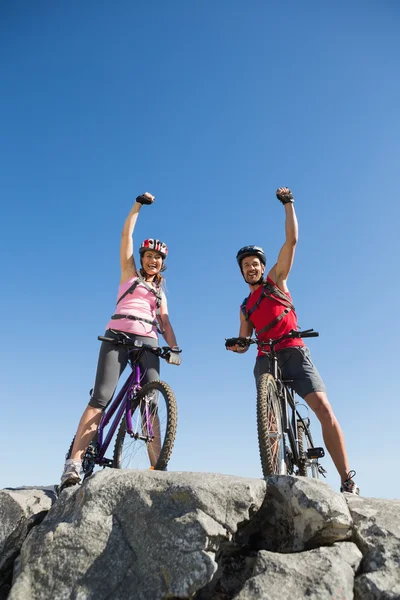 Ajuste ciclista pareja animando en la cumbre — Foto de Stock
