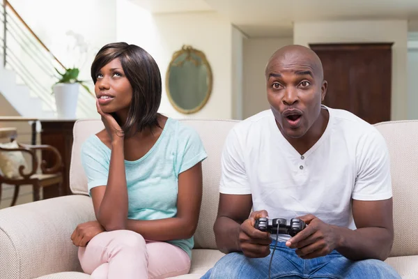 Mulher sentada ao lado de seu namorado jogando videogames — Fotografia de Stock