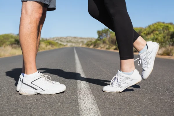 Fit couple standing on the open road together — Stock Photo, Image