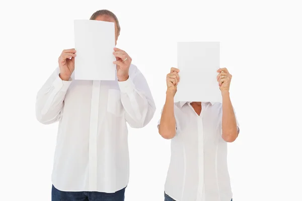 Couple tenant du papier sur leurs visages — Photo