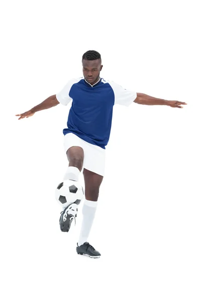Joueur de football en maillot bleu contrôlant la balle — Photo