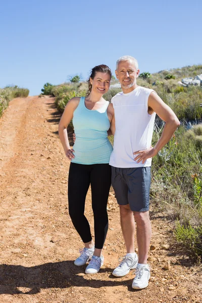 Ajuste sonriente pareja trotando por sendero de montaña —  Fotos de Stock