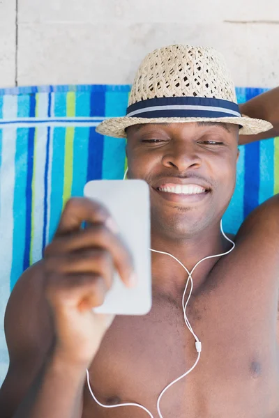 Hombre guapo sin camisa escuchando música junto a la piscina —  Fotos de Stock