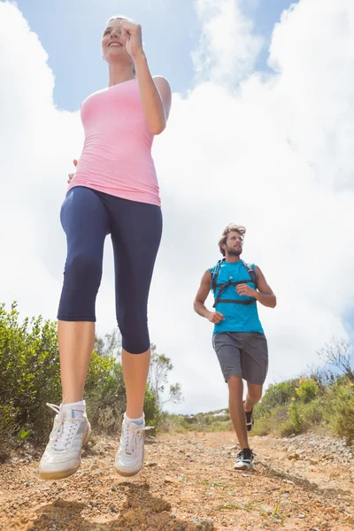 Coppia jogging giù sentiero di montagna — Foto Stock