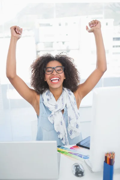 Mooie hipster juichen op haar bureau met laptop — Stockfoto