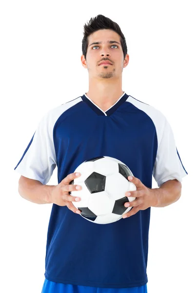 Jogador de futebol em azul segurando a bola — Fotografia de Stock