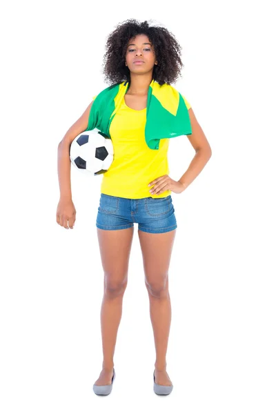 Pretty football fan holding brazilian flag looking at camera — Stock Photo, Image