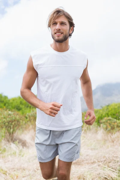 Mann joggt auf Bergpfad — Stockfoto