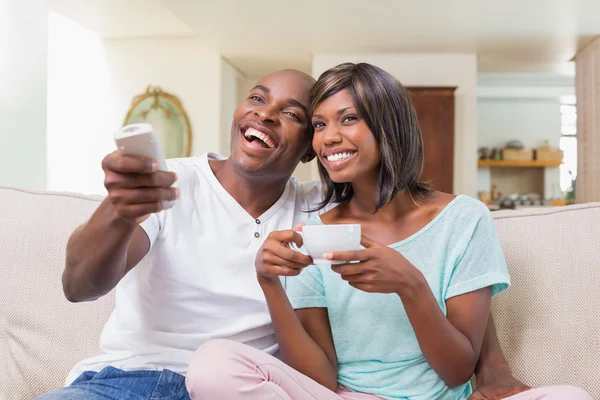 Casal feliz relaxante no sofá assistindo tv — Fotografia de Stock