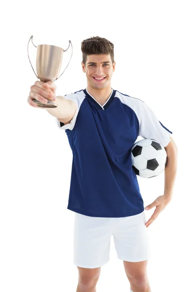 Jugador de fútbol en camiseta azul sosteniendo la copa de ganadores —  Fotos de Stock