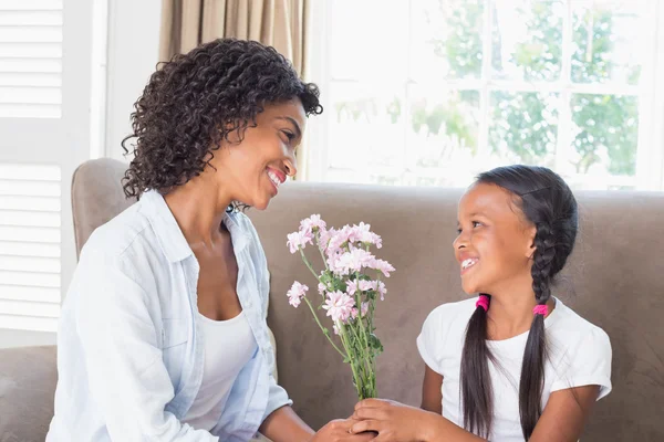 Vackra mamma med sin dotter erbjuder blommor — Stockfoto