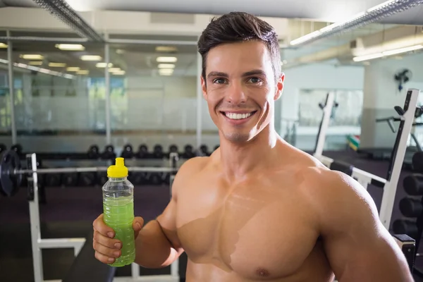 Sportlicher junger Mann mit Energy-Drink im Fitnessstudio — Stockfoto