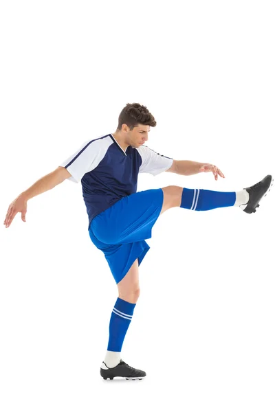 Jogador de futebol em camisa azul chutando — Fotografia de Stock