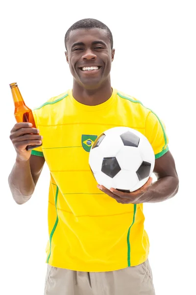 Feliz torcedor de futebol brasileiro segurando bola e cerveja — Fotografia de Stock