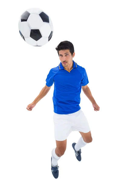 Fotbollsspelare i blå rubrik boll — Stockfoto