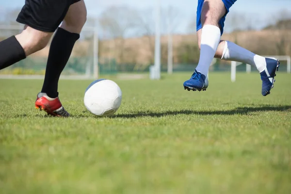 Jogadores de futebol atacando para a bola em campo — Fotografia de Stock