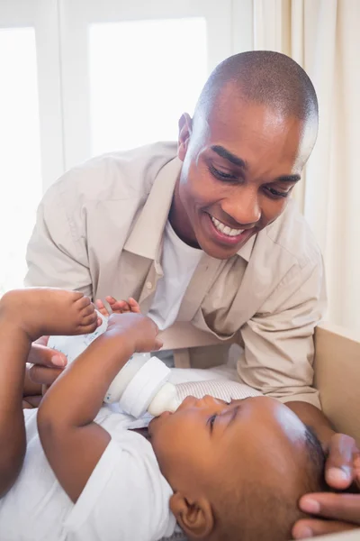 Happy father playing with his baby son in crib — Stock Photo, Image